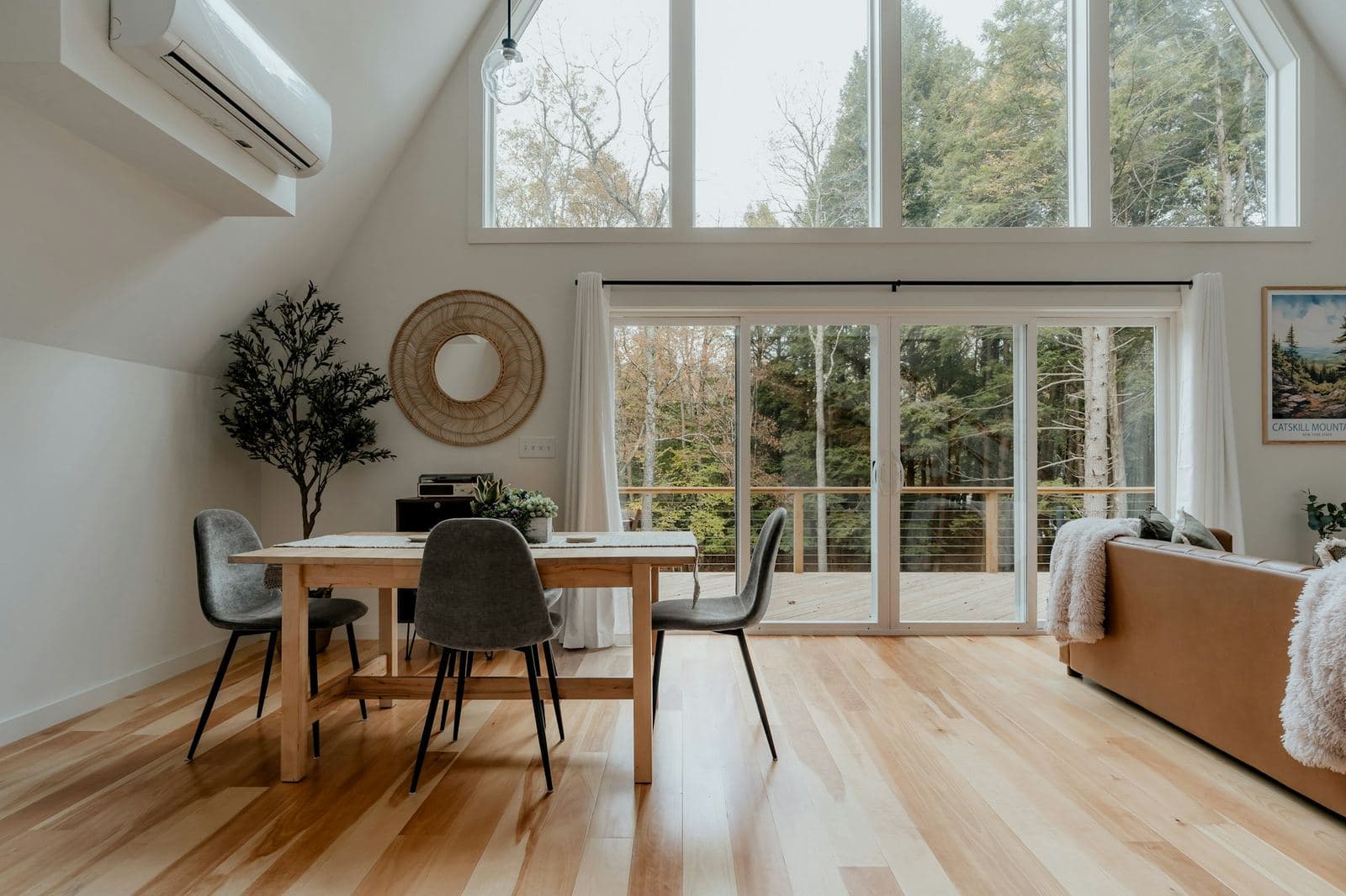 Light hardwood floors in a bright open dining and living area
