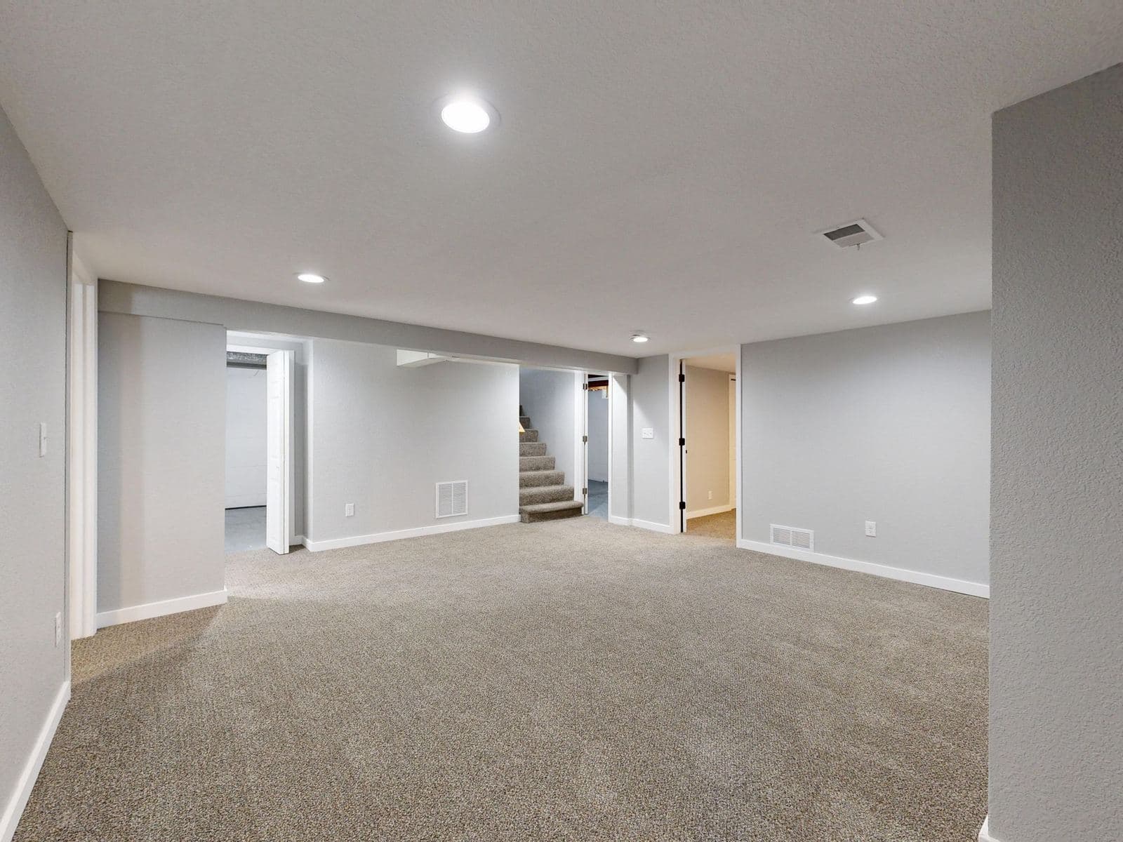 Dry finished basement with carpet, recessed lighting and neutral walls