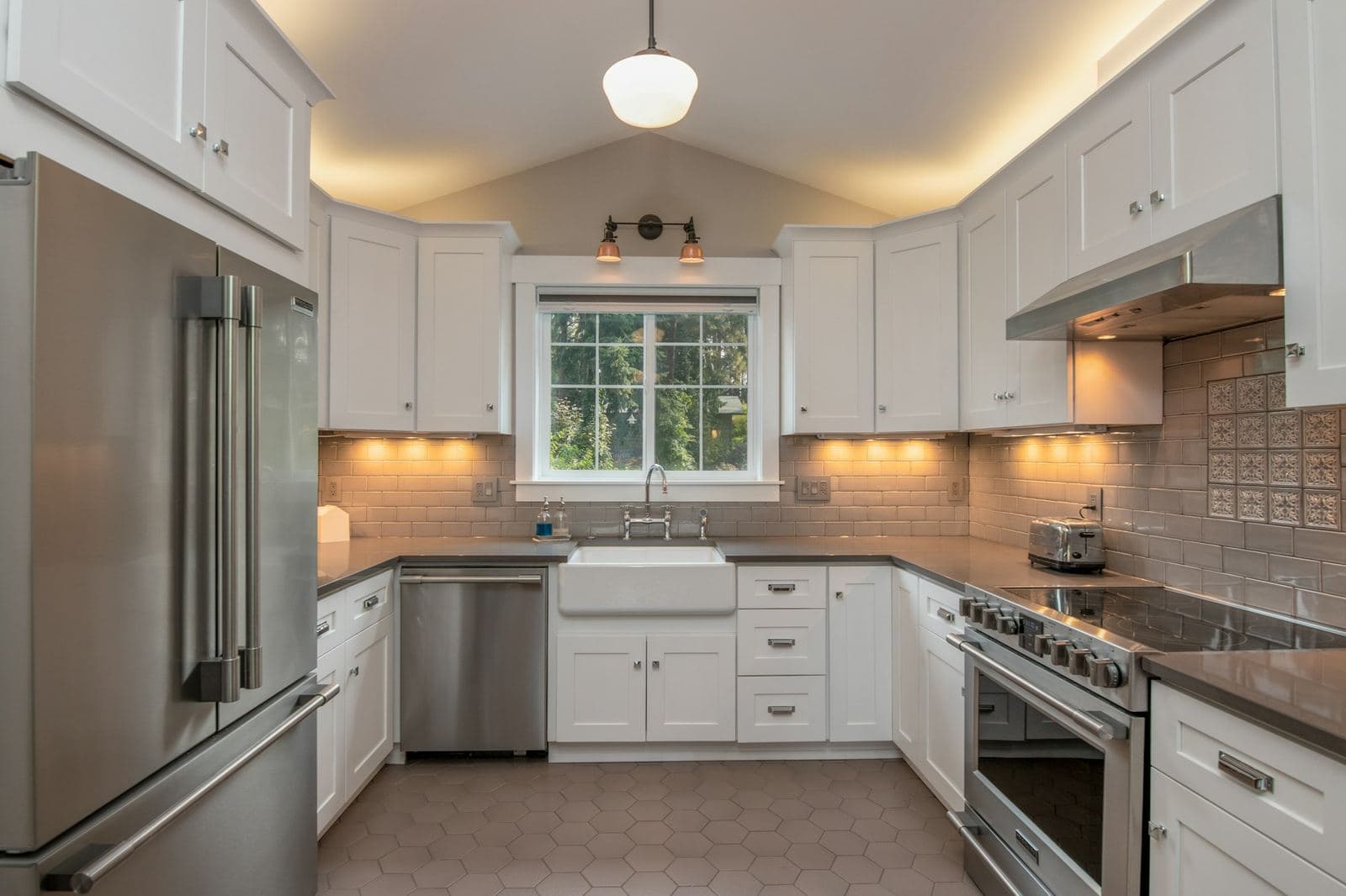 White kitchen with shaker cabinets, farmhouse sink and stainless steel appliances