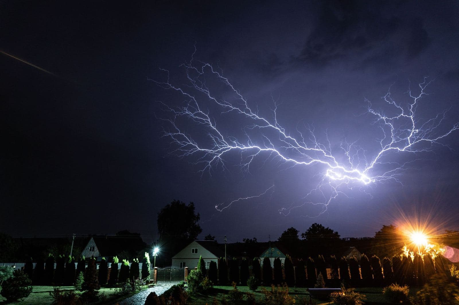 Lightning storm over houses at night, when a backup power source matters